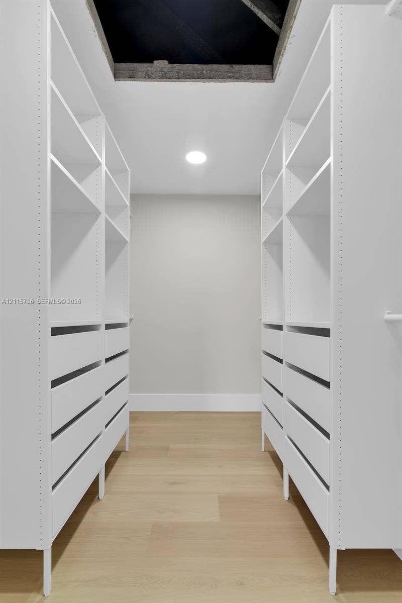 5184 Deerhurst Crescent Circle, Boca Raton, FL 33486 Custom white built-in cabinetry featuring adjustable open shelving, integrated drawers, and wood-finish flooring