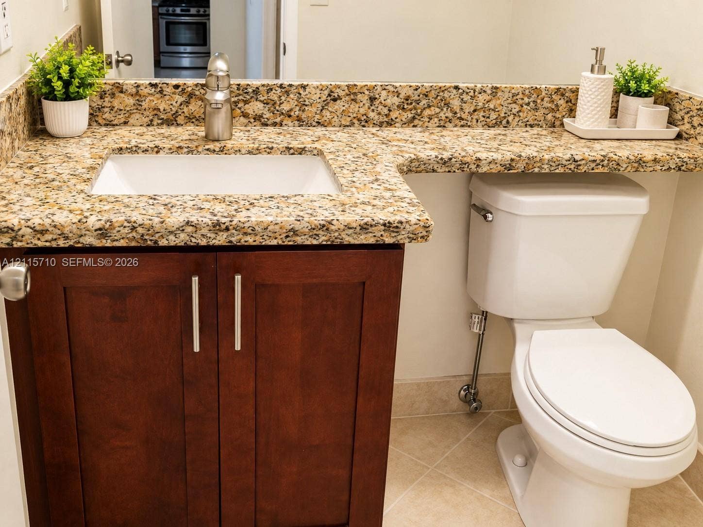406 NW 68th Avenue, #115, Plantation, Plantation, FL 33317 Bathroom vanity featuring a stone countertop with an integrated basin, undermount sink, brushed nickel faucet, and dark wood-finish cabinetry