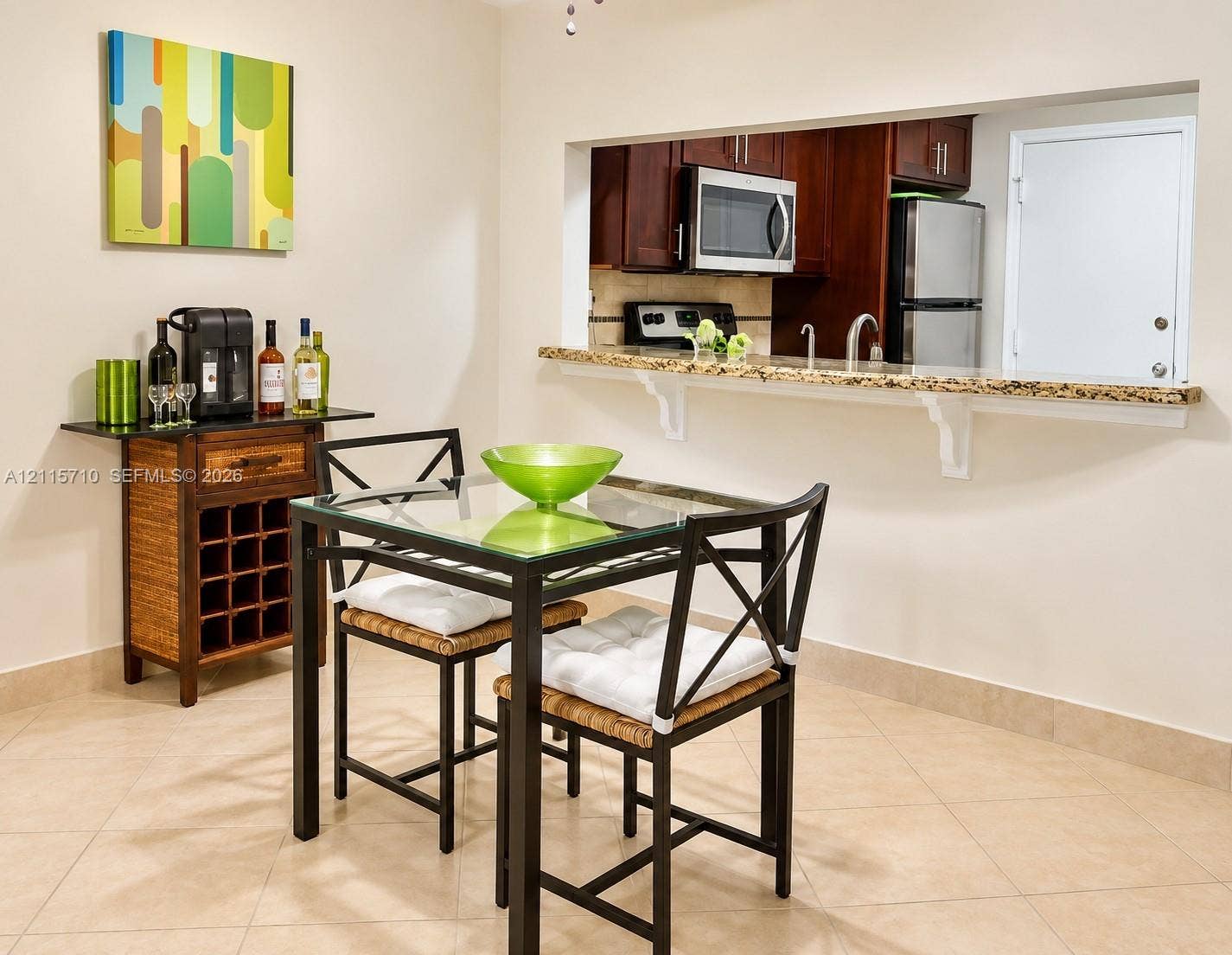406 NW 68th Avenue, #115, Plantation, Plantation, FL 33317 Pass-through window featuring a stone-topped breakfast bar, dark-finish cabinetry, built-in stainless steel microwave, and neutral tile flooring