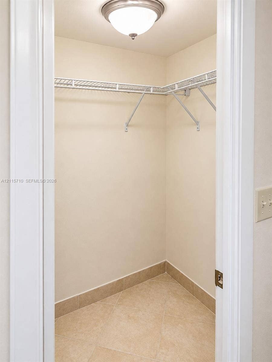 406 NW 68th Avenue, #115, Plantation, Plantation, FL 33317 Storage area featuring ceramic tile flooring, built-in wire shelving, and a ceiling-mounted light fixture