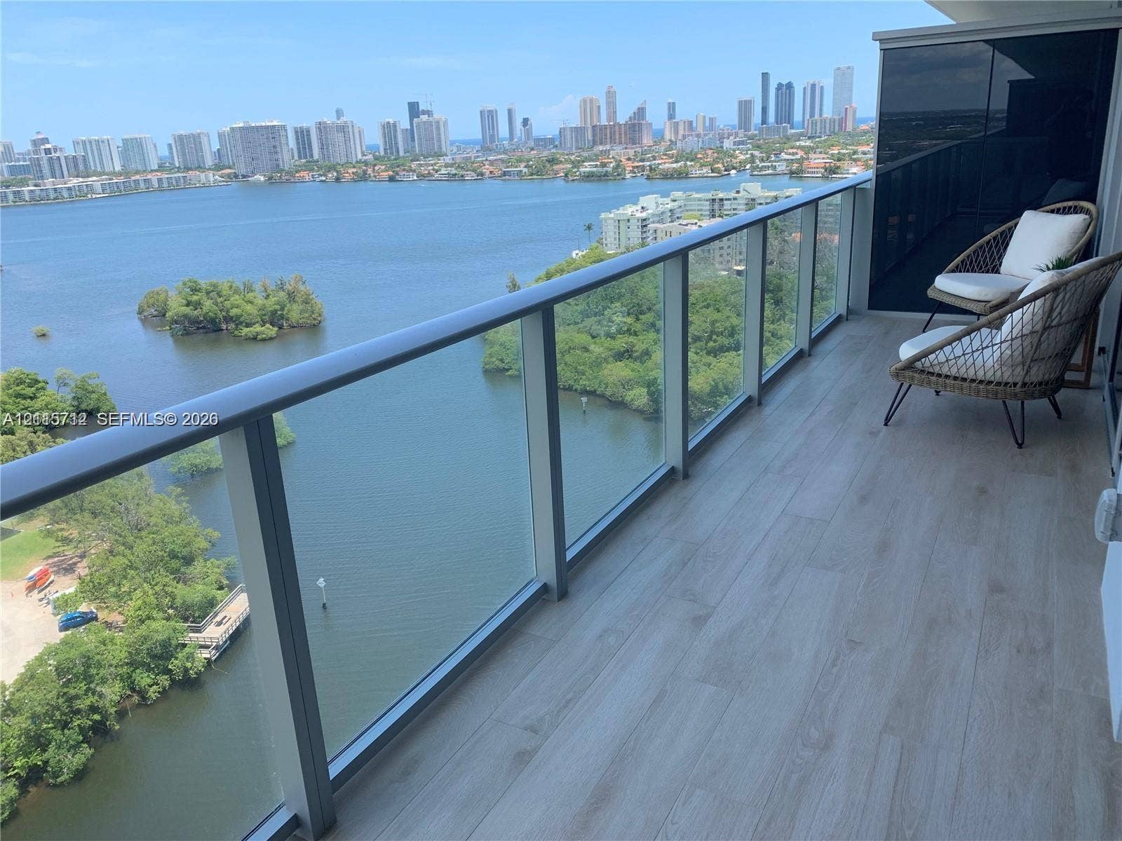16385 Biscayne Boulevard, #1906, North Miami Beach, North Miami Beach, FL 33160 Covered balcony featuring wood-finish flooring and a tempered glass railing