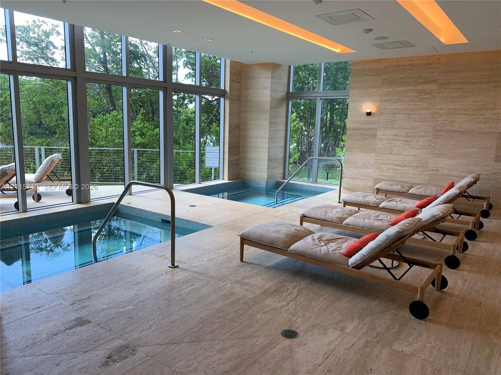 16385 Biscayne Boulevard, #1906, North Miami Beach, North Miami Beach, FL 33160 Indoor spa area featuring dual tiled soaking pools, full-height floor-to-ceiling windows, recessed cove lighting, and stone-tiled walls and flooring