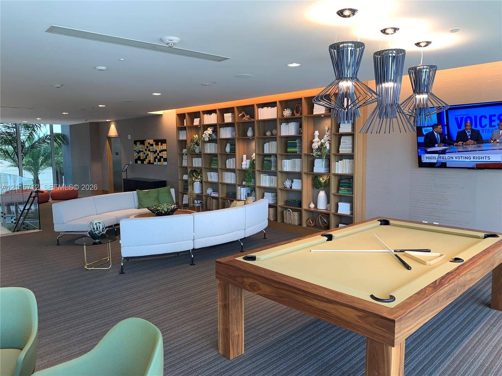 16385 Biscayne Boulevard, #1906, North Miami Beach, North Miami Beach, FL 33160 Floor-to-ceiling built-in wooden shelving, recessed ceiling lighting, textured wall-to-wall carpeting, and metal geometric pendant light fixtures