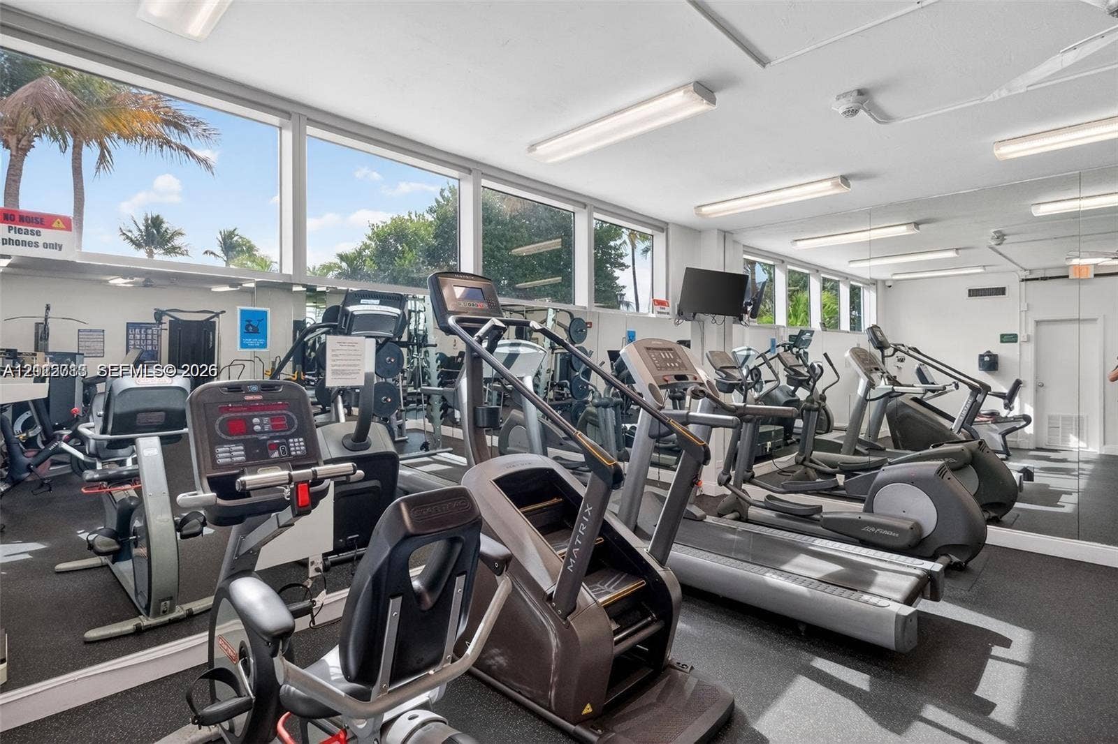 2655 Collins Avenue, #1006, Miami Beach, Miami Beach, FL 33140 Fitness center featuring wall-to-wall mirrors, floor-to-ceiling windows, and impact-resistant flooring