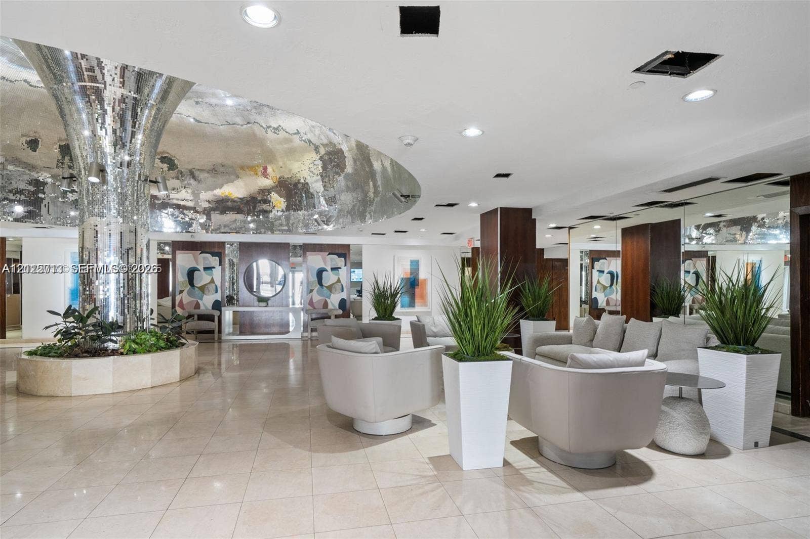 2655 Collins Avenue, #1006, Miami Beach, Miami Beach, FL 33140 Grand lobby featuring polished stone flooring, a cylindrical mirrored pillar, a circular recessed ceiling element with reflective finish, and wall-to-wall mirrored paneling