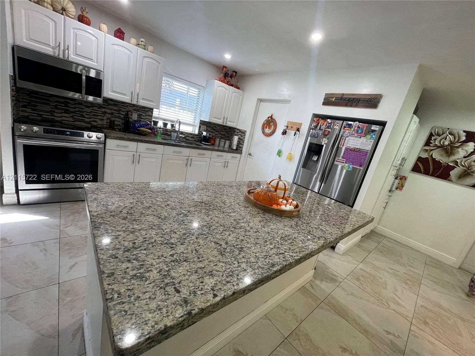 9852 SW 196th Street, Cutler Bay, FL 33157 Kitchen featuring a center island with stone countertop, white shaker-style cabinetry, stainless steel appliances, and tile flooring