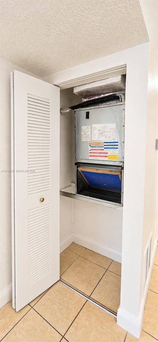11110 SW 196th Street, #212, Cutler Bay, Cutler Bay, FL 33157 Wall-mounted HVAC air handler unit with a louvered bi-fold closet door and ceramic tile flooring