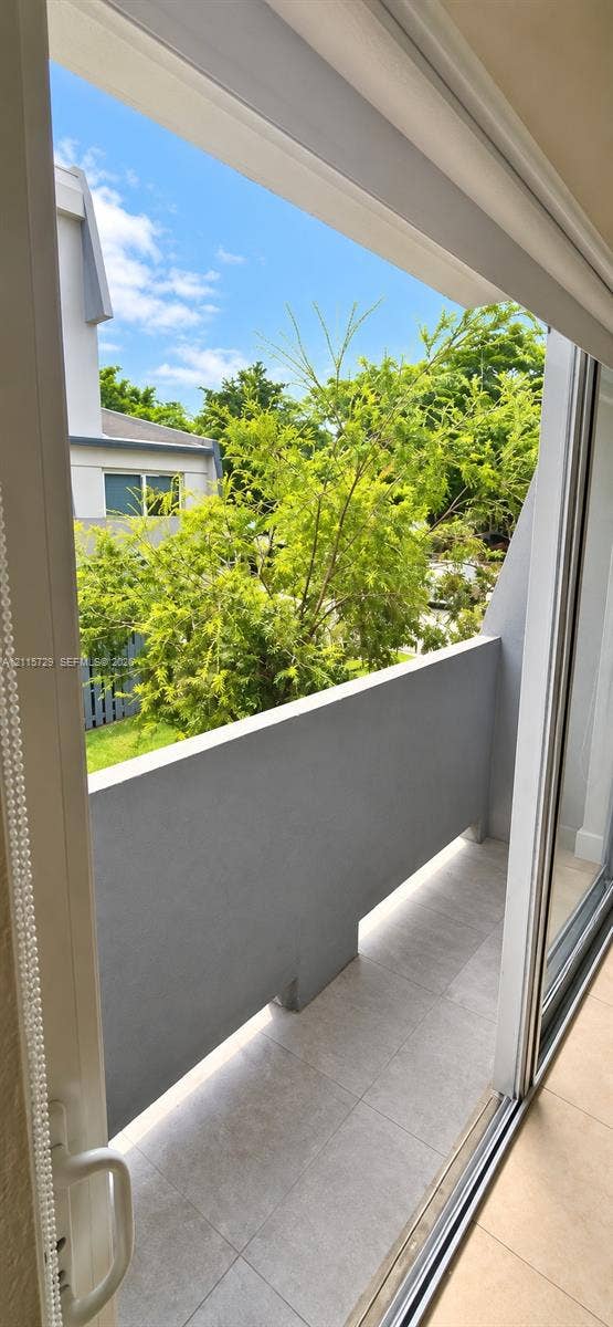 11110 SW 196th Street, #212, Cutler Bay, Cutler Bay, FL 33157 Private balcony featuring a concrete-finished floor and solid concrete railing, accessed via a sliding glass door