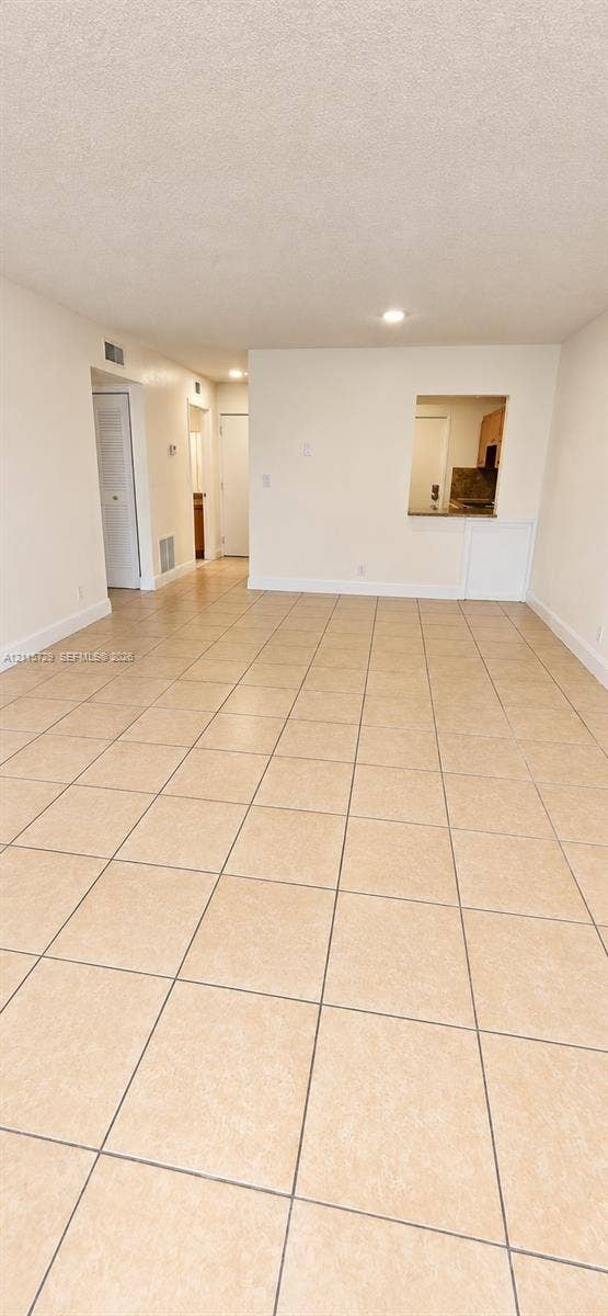 11110 SW 196th Street, #212, Cutler Bay, Cutler Bay, FL 33157 Open-concept area featuring tile flooring, smooth-finish ceilings, recessed lighting, and a pass-through opening