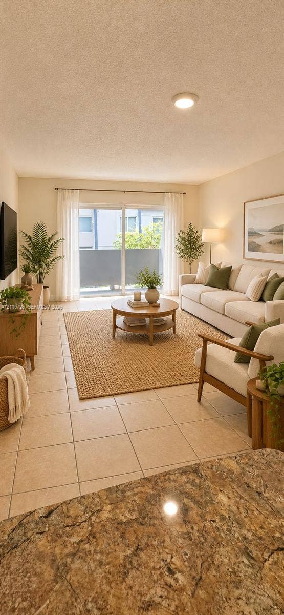 11110 SW 196th Street, #212, Cutler Bay, Cutler Bay, FL 33157 Living area featuring large-format neutral floor tile, recessed ceiling lighting, and sliding glass doors leading to an exterior balcony