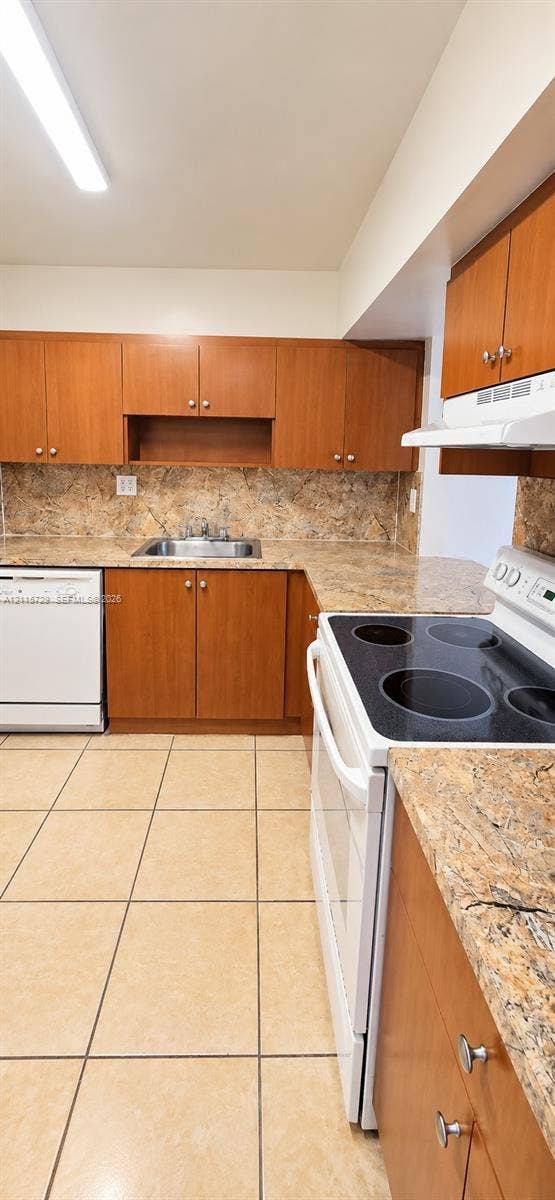 11110 SW 196th Street, #212, Cutler Bay, Cutler Bay, FL 33157 Kitchen featuring wood cabinetry, stone-finish countertops, tile flooring, and integrated white appliances