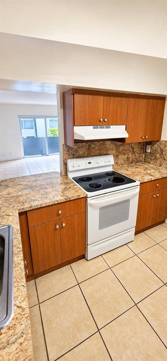 11110 SW 196th Street, #212, Cutler Bay, Cutler Bay, FL 33157 Kitchen featuring wood cabinetry, stone-surface countertops, stone-tile backsplash, white electric range, and ceramic tile flooring