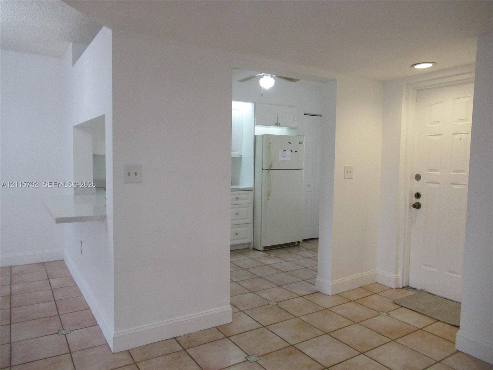 Ceramic tile flooring, built-in breakfast bar with stone-finish surface, recessed lighting, and six-panel exterior entry door