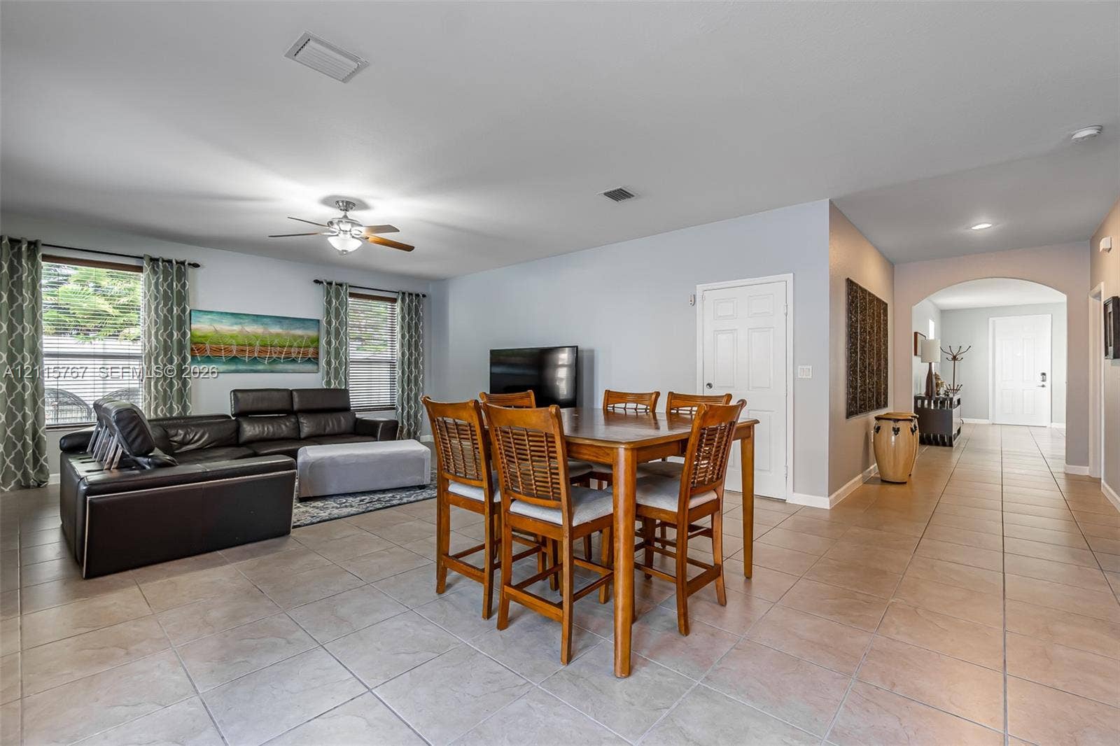 17046 SW 94th Lane, Miami, Miami, FL 33196 Open-concept interior featuring large-format ceramic tile flooring, neutral wall tones, arched entryway, and a central ceiling fan