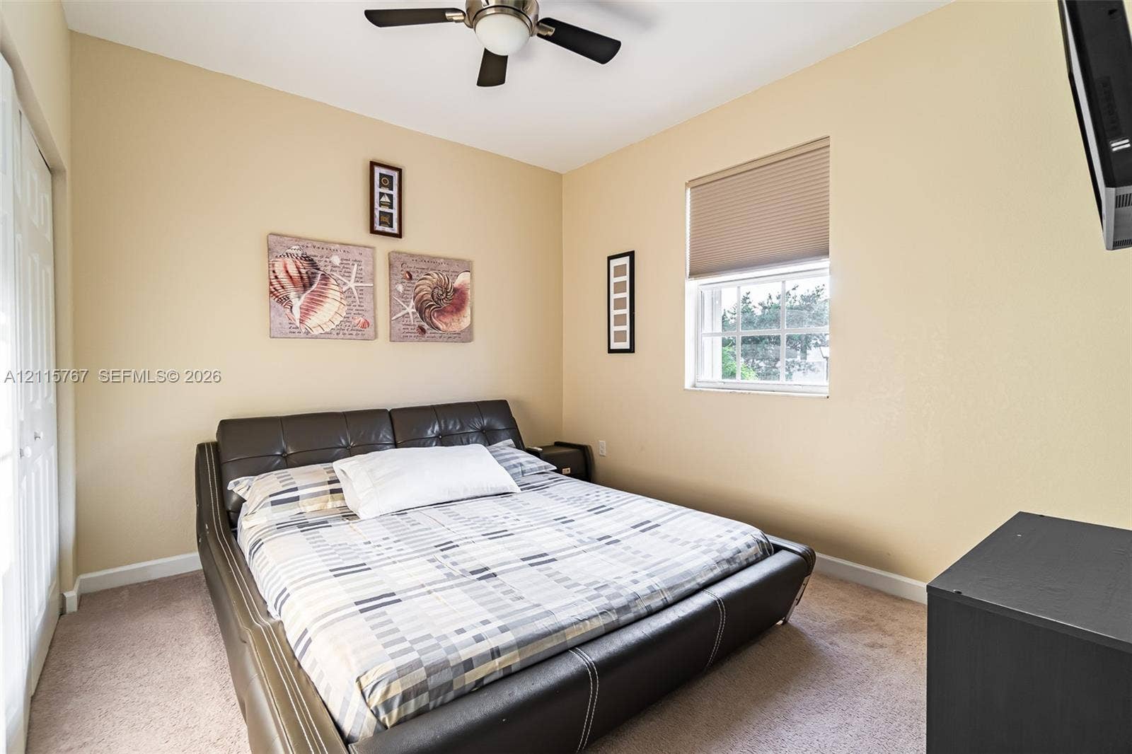 17046 SW 94th Lane, Miami, Miami, FL 33196 Neutral-toned interior featuring carpeting, a multi-pane window with a retractable shade, and a ceiling-mounted fan with an integrated light fixture