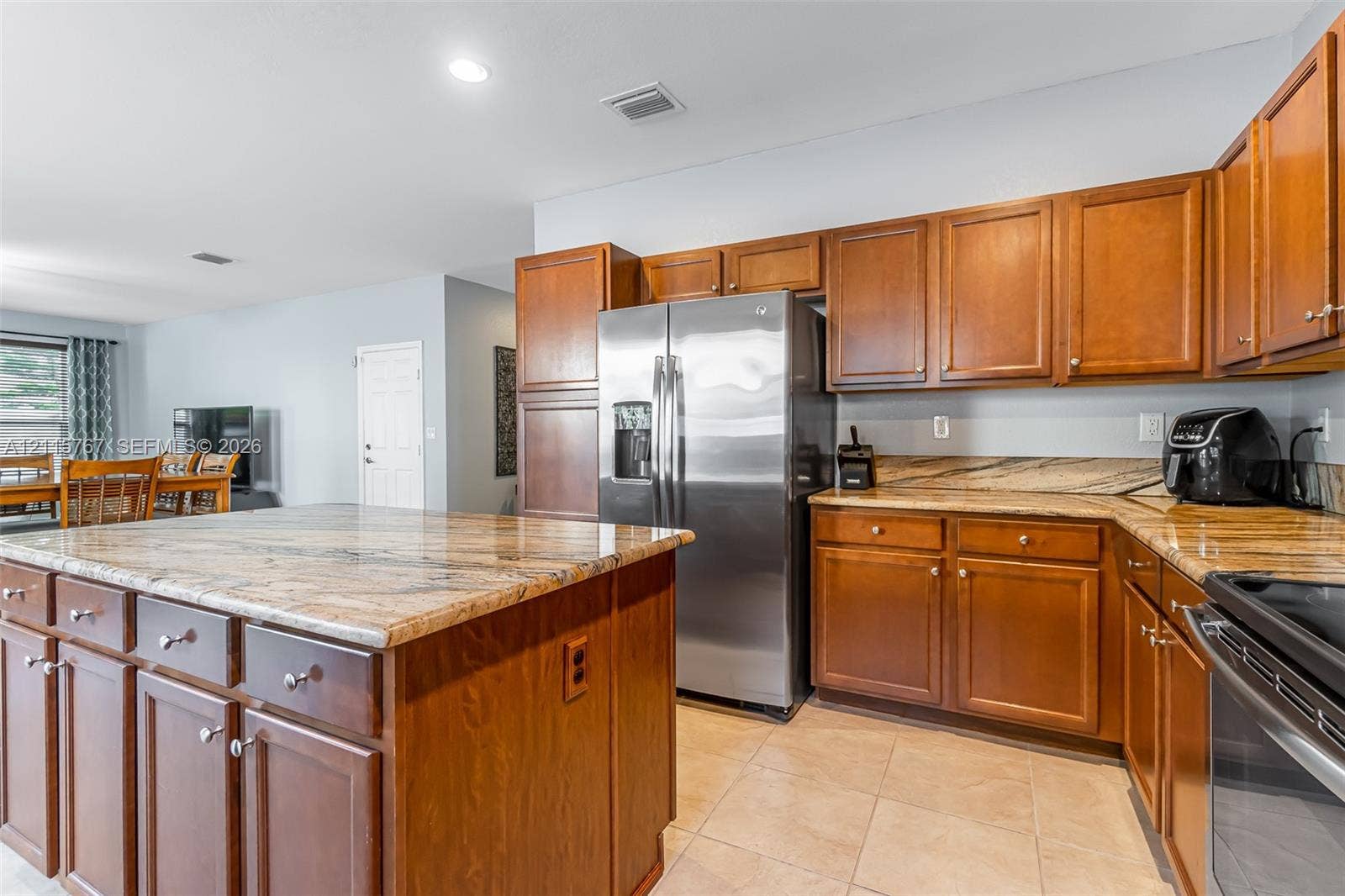 17046 SW 94th Lane, Miami, Miami, FL 33196 Kitchen featuring wood cabinetry, stone countertops, a center island, tile flooring, and stainless steel appliances