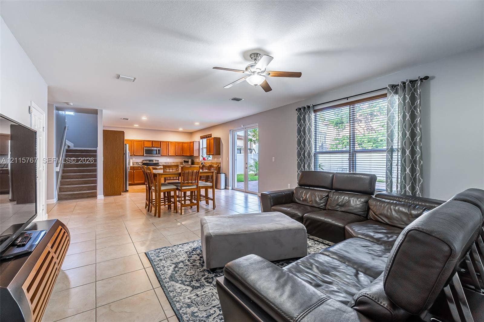 17046 SW 94th Lane, Miami, Miami, FL 33196 Open-concept floor plan featuring tile flooring, ceiling fan, wood-finish cabinetry, and glass sliding doors
