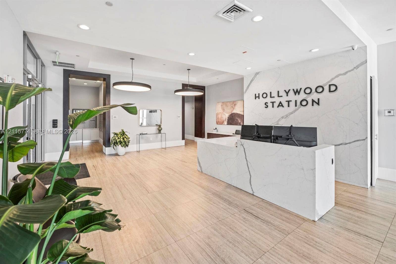 140 S Dixie Highway, #433, Hollywood, Hollywood, FL 33020 Lobby featuring stone-surround reception desk, wood-finish flooring, recessed lighting, and large pendant light fixtures