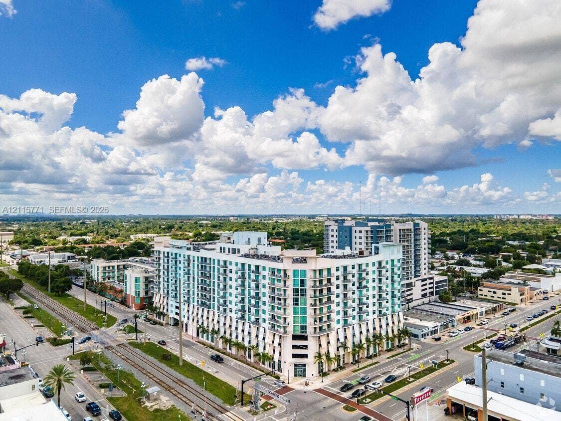 140 S Dixie Highway, #433, Hollywood, Hollywood, FL 33020 Multi-story residential building featuring a glass facade, private balconies, and ground-level storefronts