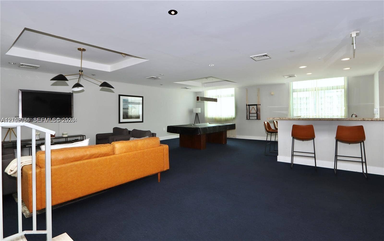 140 S Dixie Highway, #433, Hollywood, Hollywood, FL 33020 Open-concept room featuring a recessed tray ceiling, multi-arm chandelier, and a built-in counter with a stone surface