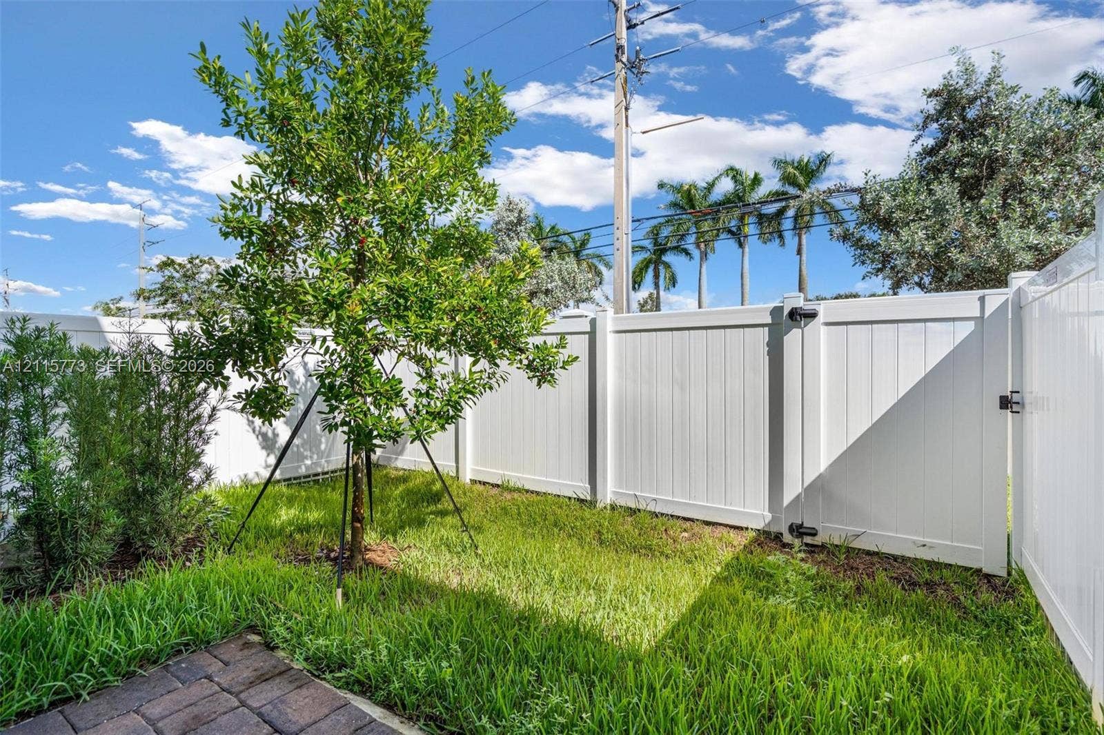 17033 SW 1st Street, #1, Pembroke Pines, Pembroke Pines, FL 33027 Private outdoor space featuring a white vinyl privacy fence, paver patio, and grass lawn