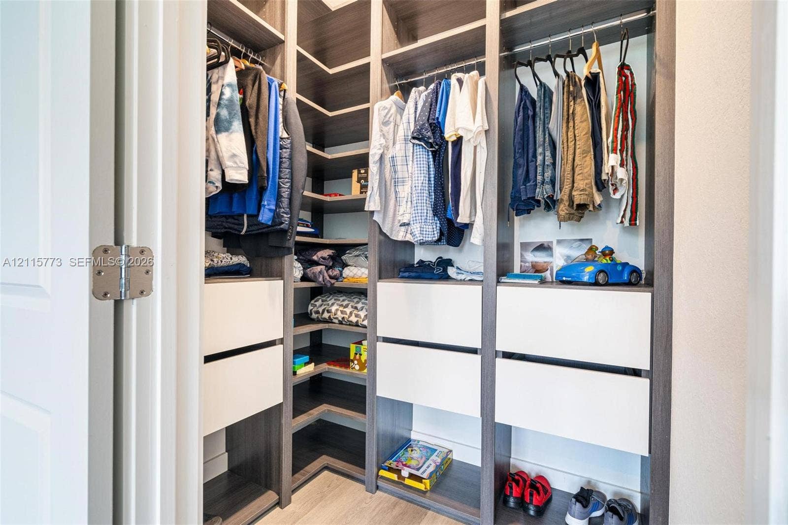 17033 SW 1st Street, #1, Pembroke Pines, Pembroke Pines, FL 33027 Walk-in closet featuring floor-to-ceiling built-in cabinetry, multi-level hanging rods, corner shelving, and integrated soft-close drawers with a dual-tone wood-finish