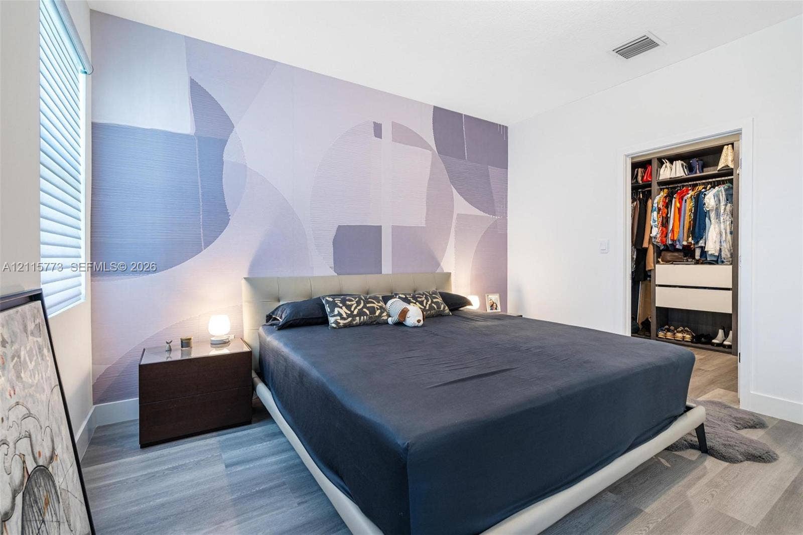 17033 SW 1st Street, #1, Pembroke Pines, Pembroke Pines, FL 33027 Room featuring a patterned accent wall, wood-finish flooring, and a walk-in closet with built-in shelving