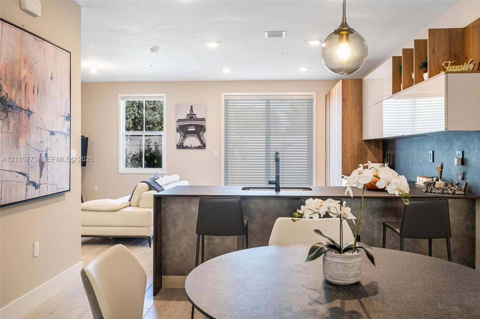 17033 SW 1st Street, #1, Pembroke Pines, Pembroke Pines, FL 33027 Kitchen featuring a central island with a sink and matte black faucet, gloss-finish upper cabinetry, open wood-tone shelving, and recessed lighting