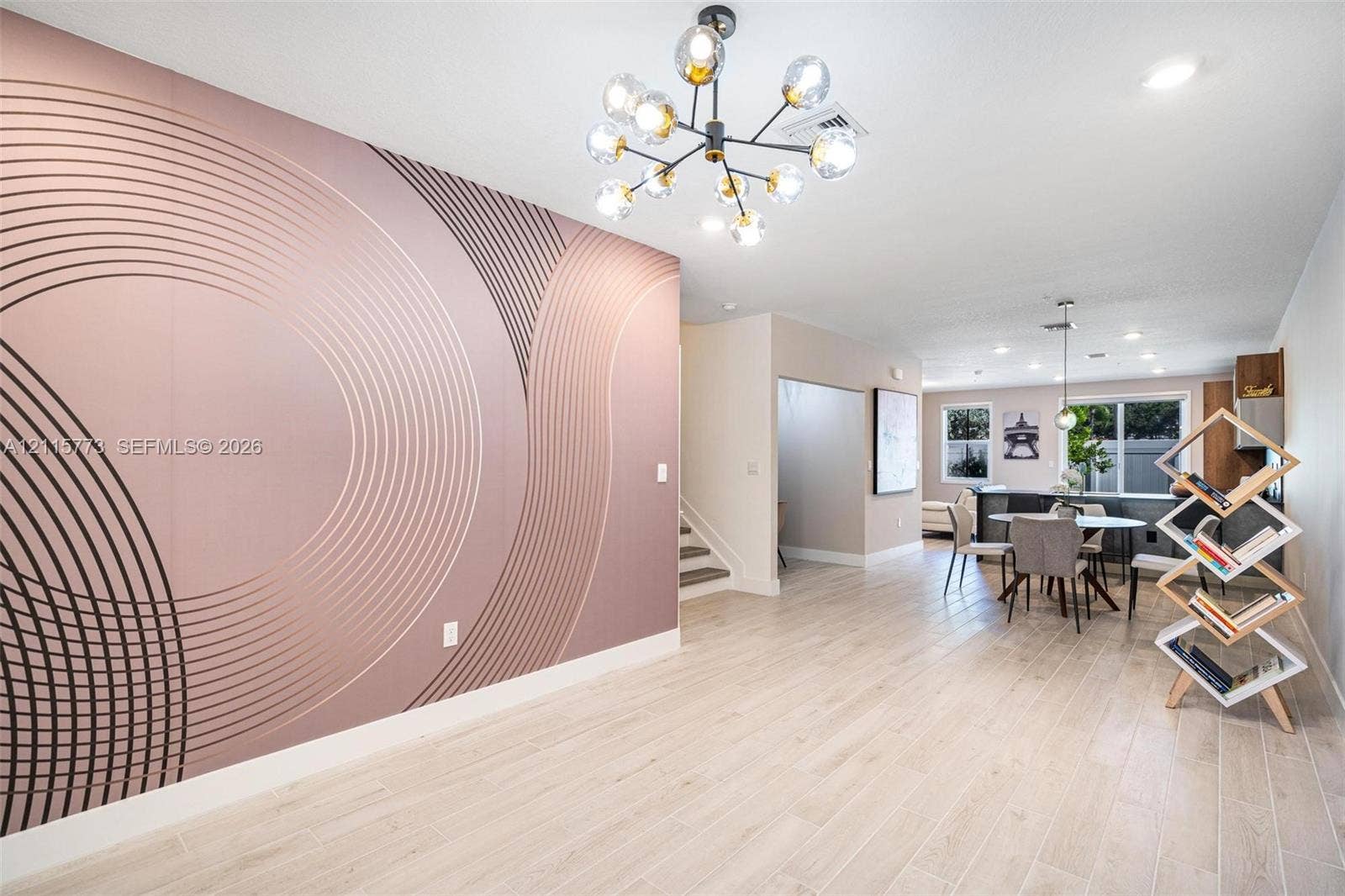 17033 SW 1st Street, #1, Pembroke Pines, Pembroke Pines, FL 33027 Accent wall with geometric patterning, wood-finish flooring, multi-globe chandelier, and recessed lighting
