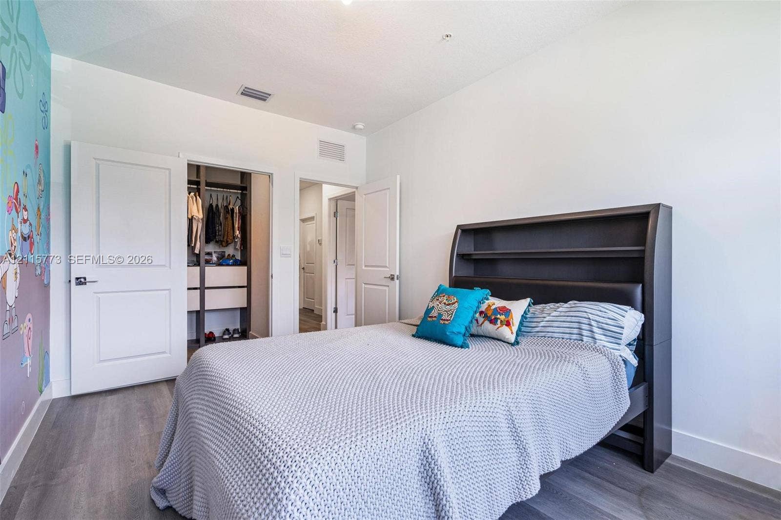 17033 SW 1st Street, #1, Pembroke Pines, Pembroke Pines, FL 33027 Interior space featuring wood-finish flooring, white paneled doors, and a built-in closet system with integrated shelving