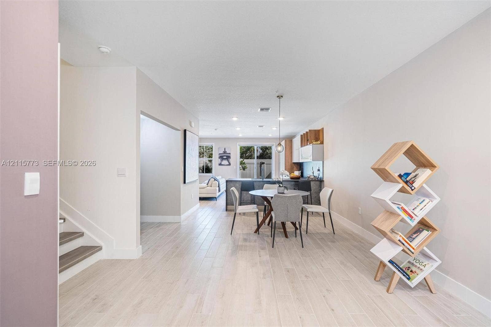 17033 SW 1st Street, #1, Pembroke Pines, Pembroke Pines, FL 33027 Open-concept interior featuring light wood-finish flooring, recessed lighting, a modern kitchen with dark cabinetry, and a suspended pendant light fixture