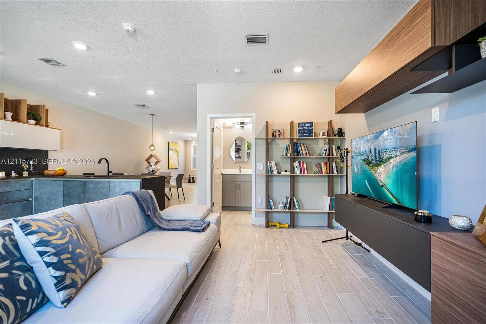 17033 SW 1st Street, #1, Pembroke Pines, Pembroke Pines, FL 33027 Open-concept interior featuring light wood-finish flooring, recessed lighting, and wall-mounted cabinetry with integrated shelving