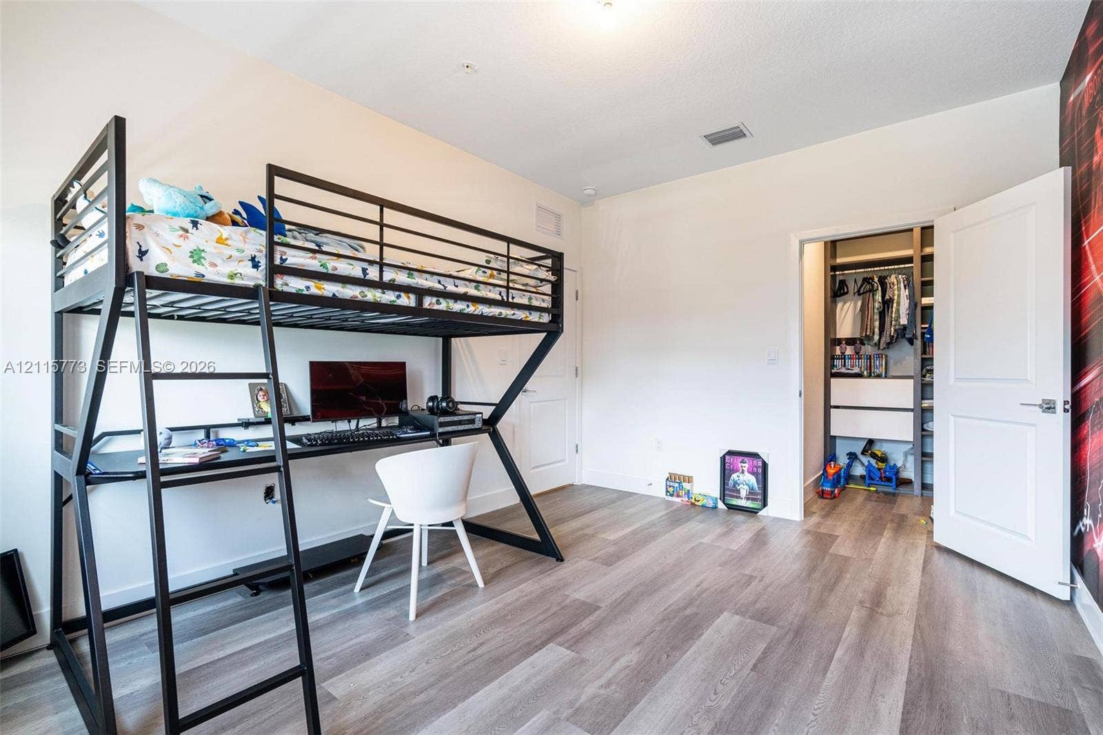 17033 SW 1st Street, #1, Pembroke Pines, Pembroke Pines, FL 33027 Interior space featuring light-toned wood-finish flooring, high ceilings, and a walk-in closet equipped with built-in shelving and drawers