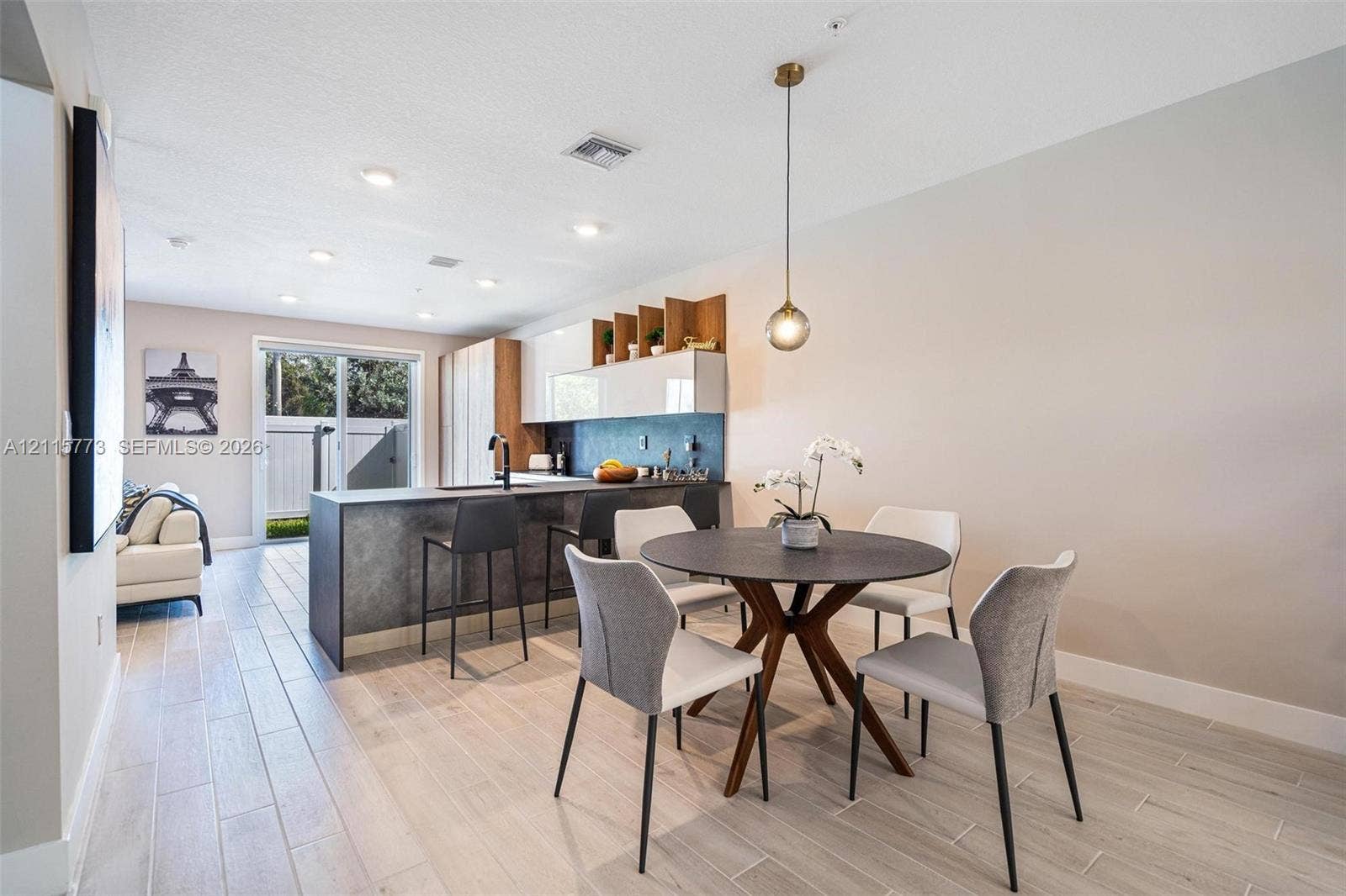 17033 SW 1st Street, #1, Pembroke Pines, Pembroke Pines, FL 33027 Kitchen featuring a textured charcoal island, wood-finish cabinetry with glossy white upper cupboards, recessed lighting, and wood-finish flooring