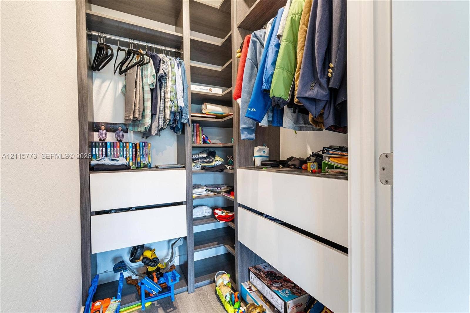 17033 SW 1st Street, #1, Pembroke Pines, Pembroke Pines, FL 33027 Custom built-in closet organization system featuring dark wood-finish cabinetry, white matte-finish drawers, adjustable shelving, and integrated clothing rods