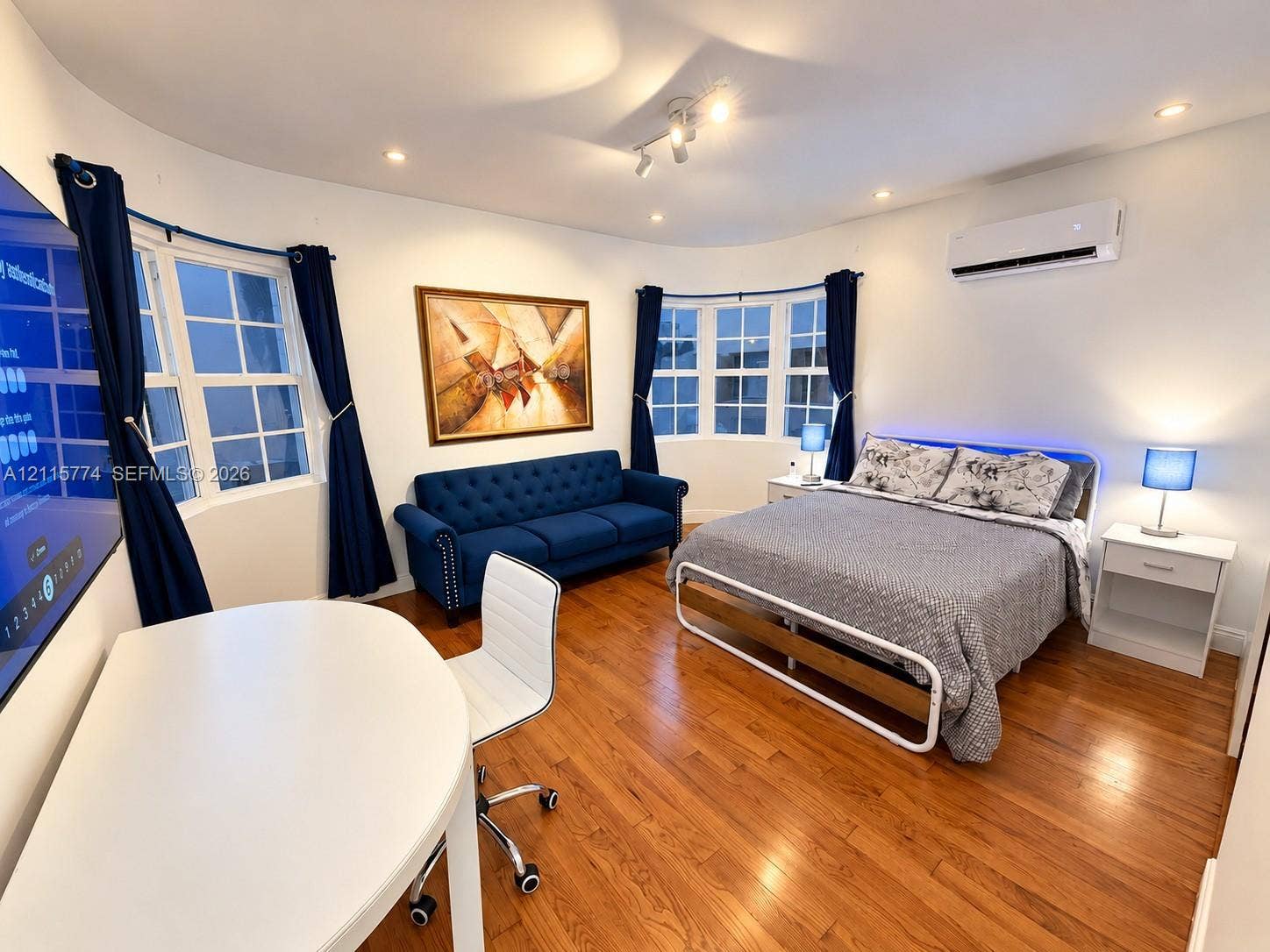 1455 Michigan Avenue, #19A, Miami Beach, Miami Beach, FL 33139 Room featuring wood-finish flooring, two large bay window sets with divided-light panes, recessed lighting, and a wall-mounted ductless climate control unit