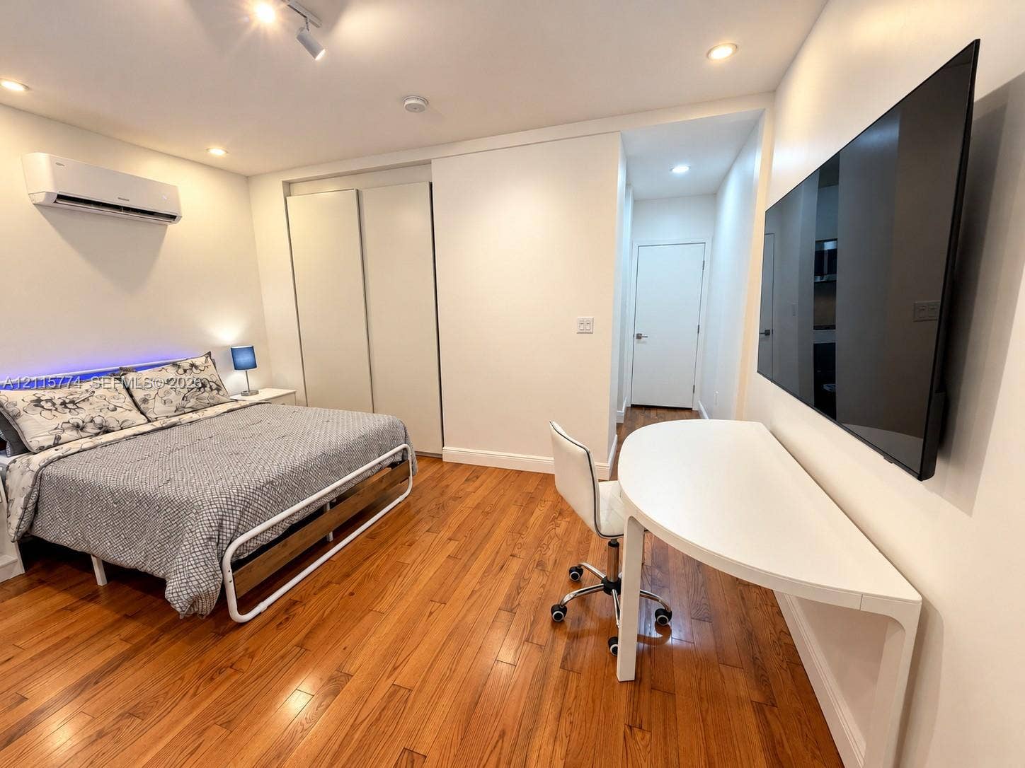 1455 Michigan Avenue, #19A, Miami Beach, Miami Beach, FL 33139 Wood-finish flooring, recessed ceiling lighting, wall-mounted air conditioning unit, and built-in closet with sliding doors