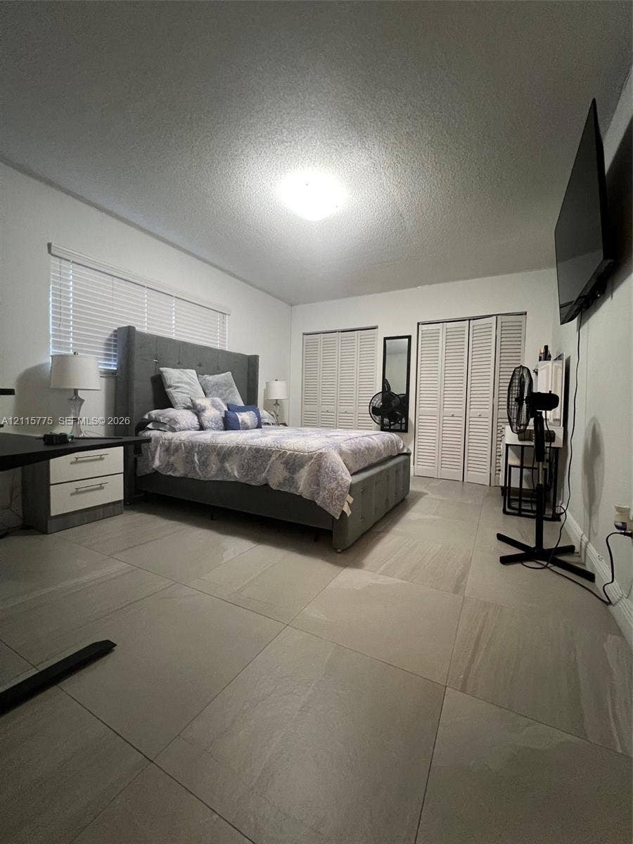 479 E 13th Street, #479, Hialeah, Hialeah, FL 33010 Large-format neutral floor tiling, louvered bi-fold closet doors, and horizontal slat window blinds