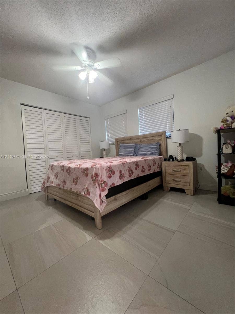 479 E 13th Street, #479, Hialeah, Hialeah, FL 33010 Large-format tile flooring, louvered closet doors, and a ceiling fan with integrated lighting