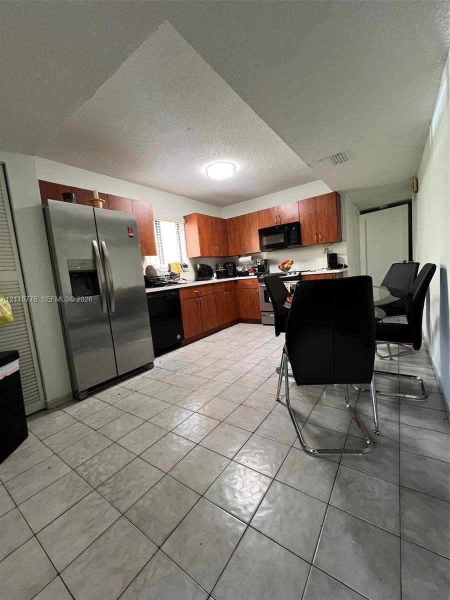 479 E 13th Street, #479, Hialeah, Hialeah, FL 33010 Kitchen featuring wood cabinetry, stainless steel side-by-side refrigerator, built-in microwave, and tile flooring