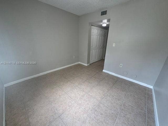 Neutral-toned interior space featuring ceramic tile flooring and a double-panel closet with white doors