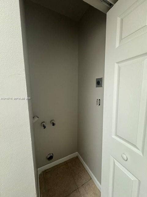 Utility alcove featuring tile flooring, neutral wall paint, and dedicated plumbing connections