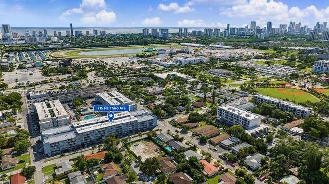 215 SE 3rd Avenue, #501B, Hallandale Beach, FL 33009 Aerial perspective of multi-story residential building featuring a swimming pool, flat roofing, and proximity to municipal park grounds