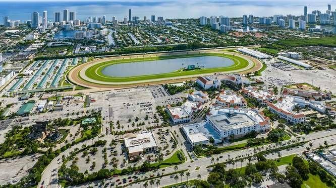 215 SE 3rd Avenue, #501B, Hallandale Beach, FL 33009 Aerial perspective featuring a racetrack, extensive parking facilities, and proximity to metropolitan buildings and coastal waters