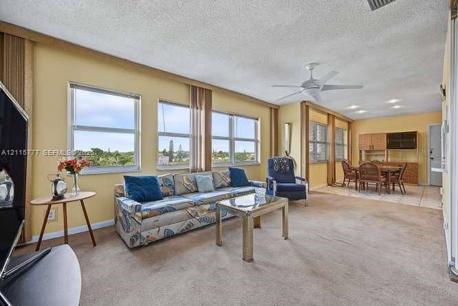 215 SE 3rd Avenue, #501B, Hallandale Beach, FL 33009 Living area featuring expansive multi-pane windows, ceiling-mounted paddle fan, recessed lighting, and built-in cabinetry