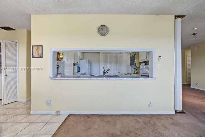 215 SE 3rd Avenue, #501B, Hallandale Beach, FL 33009 Pass-through service window featuring a stone-look countertop, integrated double-basin sink with a gooseneck faucet, and a decorative column accent