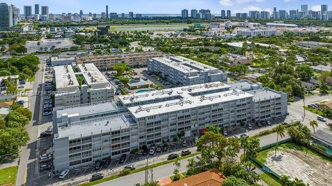 215 SE 3rd Avenue, #501B, Hallandale Beach, FL 33009 Aerial perspective of a multi-story residential complex featuring flat roof architecture, surface parking, and a central swimming pool