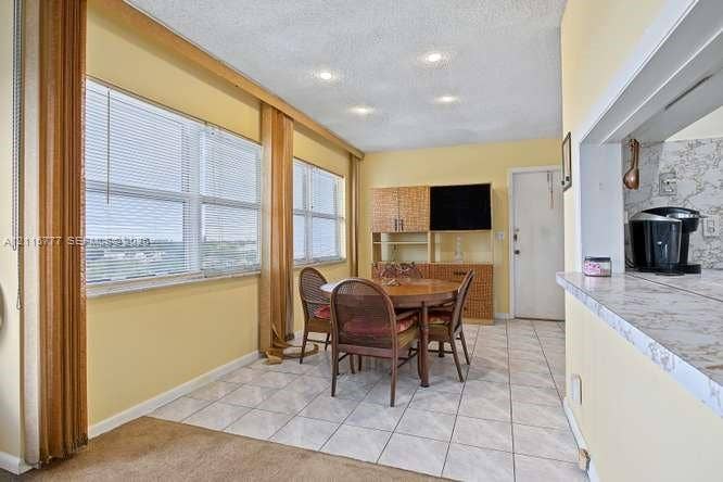 215 SE 3rd Avenue, #501B, Hallandale Beach, FL 33009 Large windows with exterior scenery, tile flooring, recessed ceiling lighting, and a kitchen pass-through with stone-finish countertop