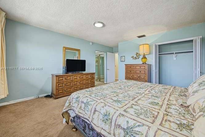 215 SE 3rd Avenue, #501B, Hallandale Beach, FL 33009 Neutral-toned carpet flooring, textured ceiling, and a built-in closet with bi-fold doors