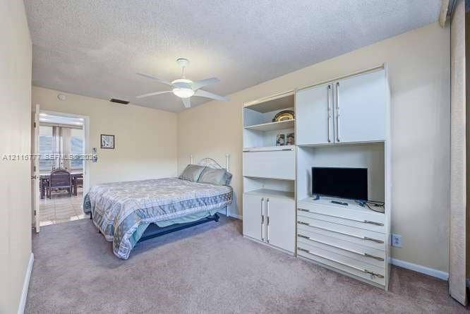 215 SE 3rd Avenue, #501B, Hallandale Beach, FL 33009 Neutral wall tones, carpeted flooring, built-in white cabinetry with integrated shelving and drawers, and a ceiling fan with light fixture